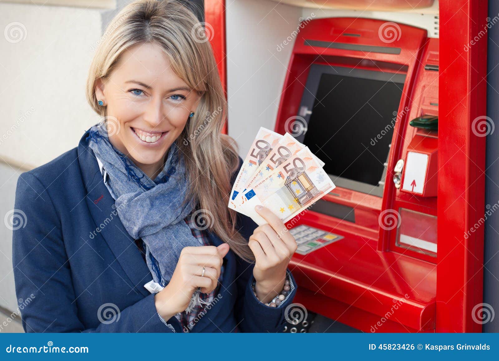 happy woman withdrawing cash from atm