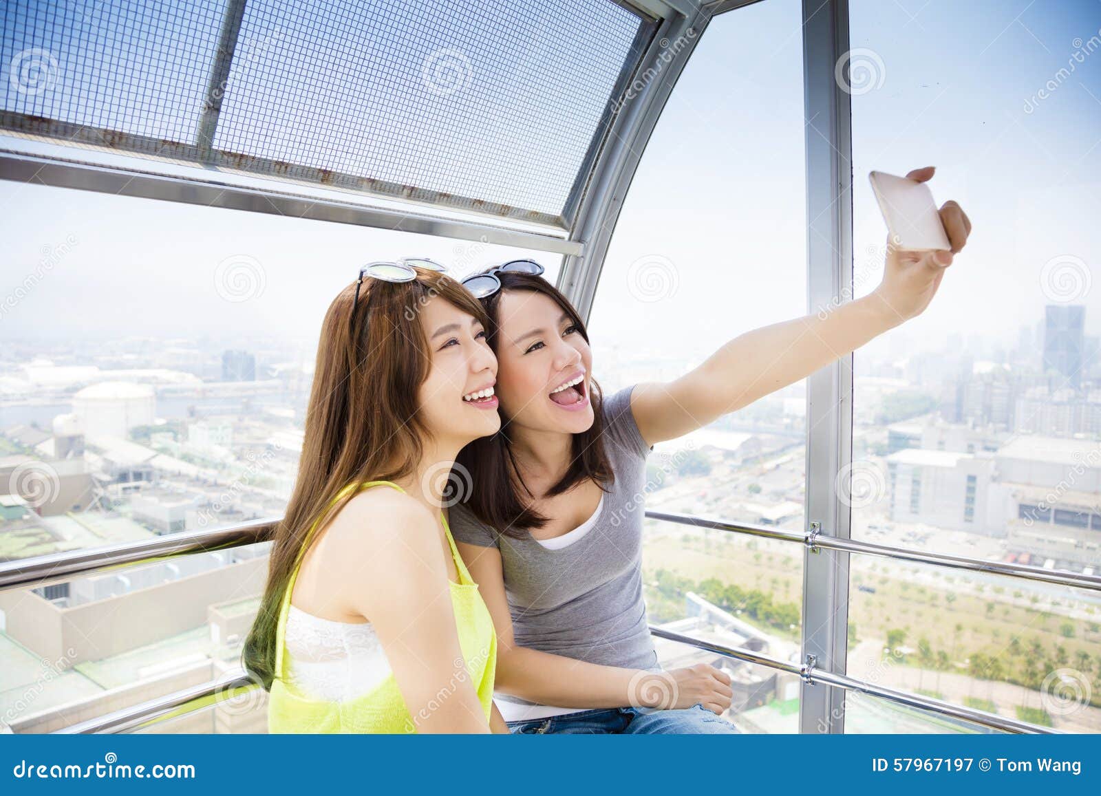 happy women girlfriends taking a selfie in ferris wheel