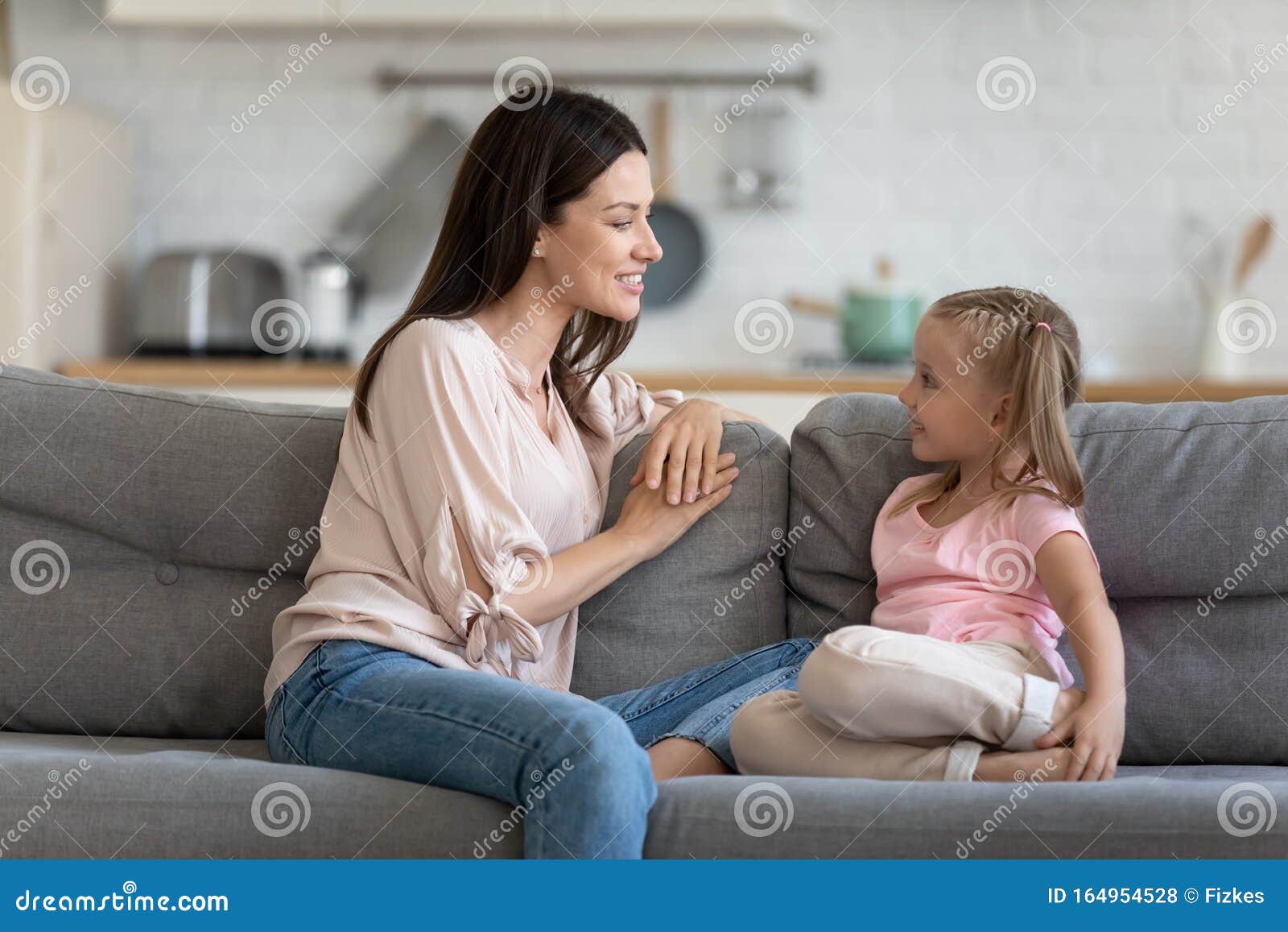 happy mother and cute child enjoy talking relaxing on sofa