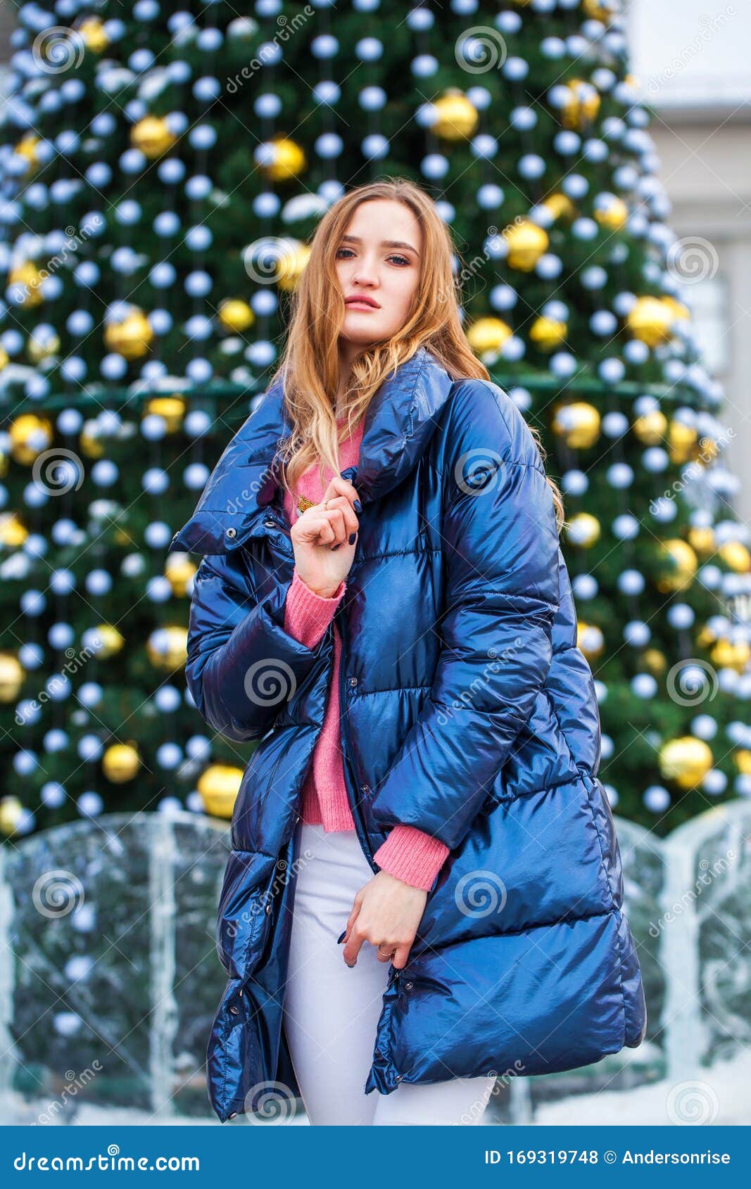 Young Blonde Woman in Blue Down Jacket in Winter Street Stock Photo ...