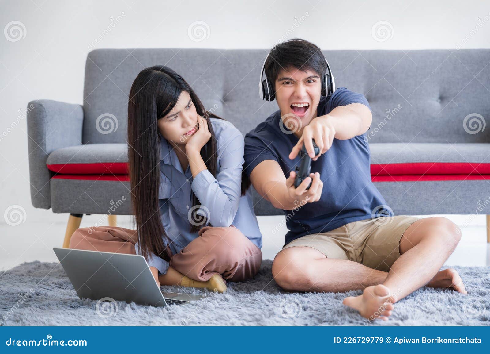 Happy boyfriend and girlfriend playing video games and holding