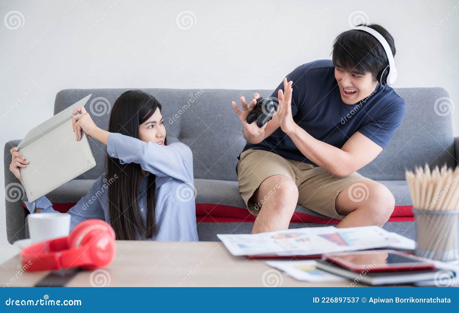 Happy boyfriend and girlfriend playing video games and holding