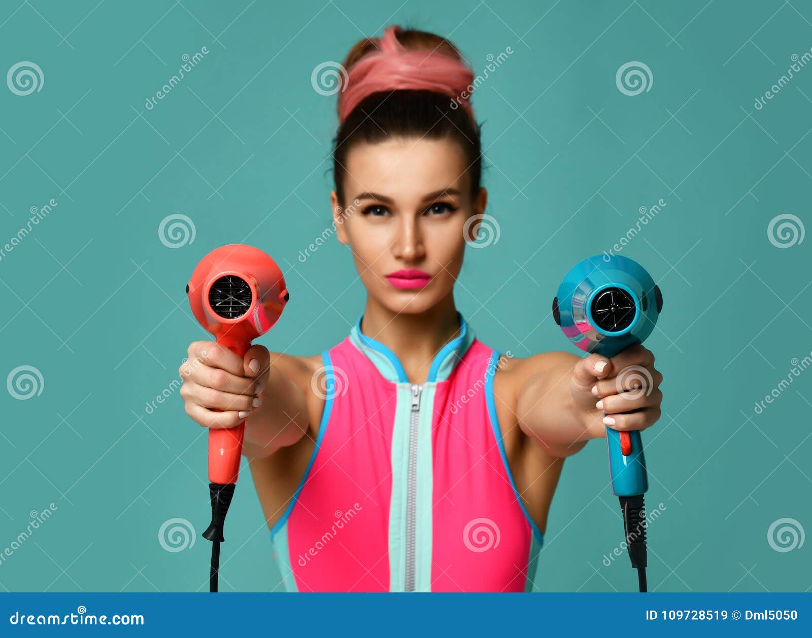 happy young brunette woman with hair dryer on blue mint background