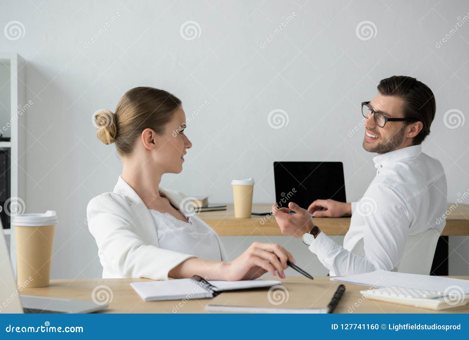 happy young business colleagues chatting at workplace