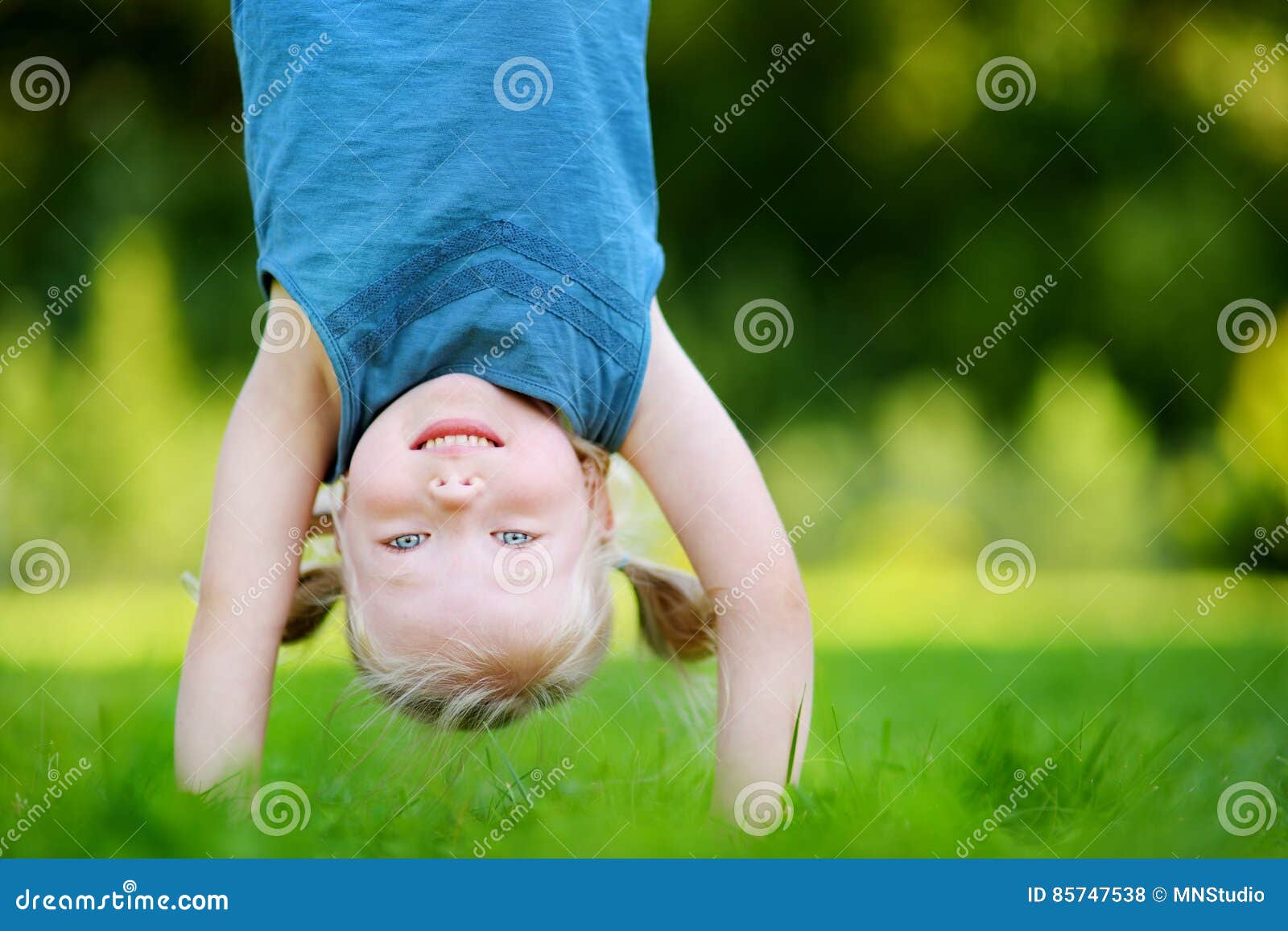 Happy Young Child Playing Head Over Heels on a Grass in Spring Park ...