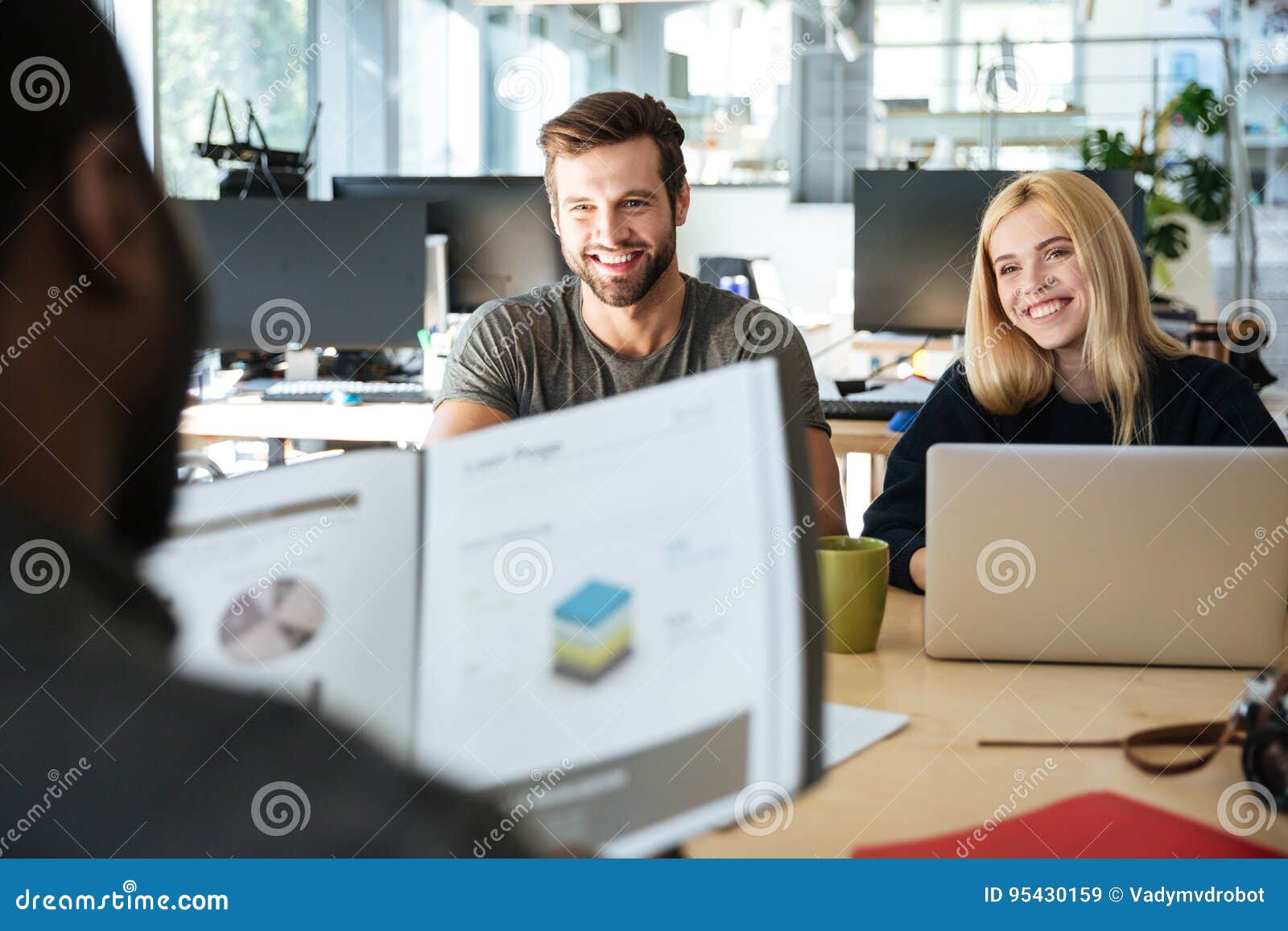 happy young colleagues sitting in office coworking