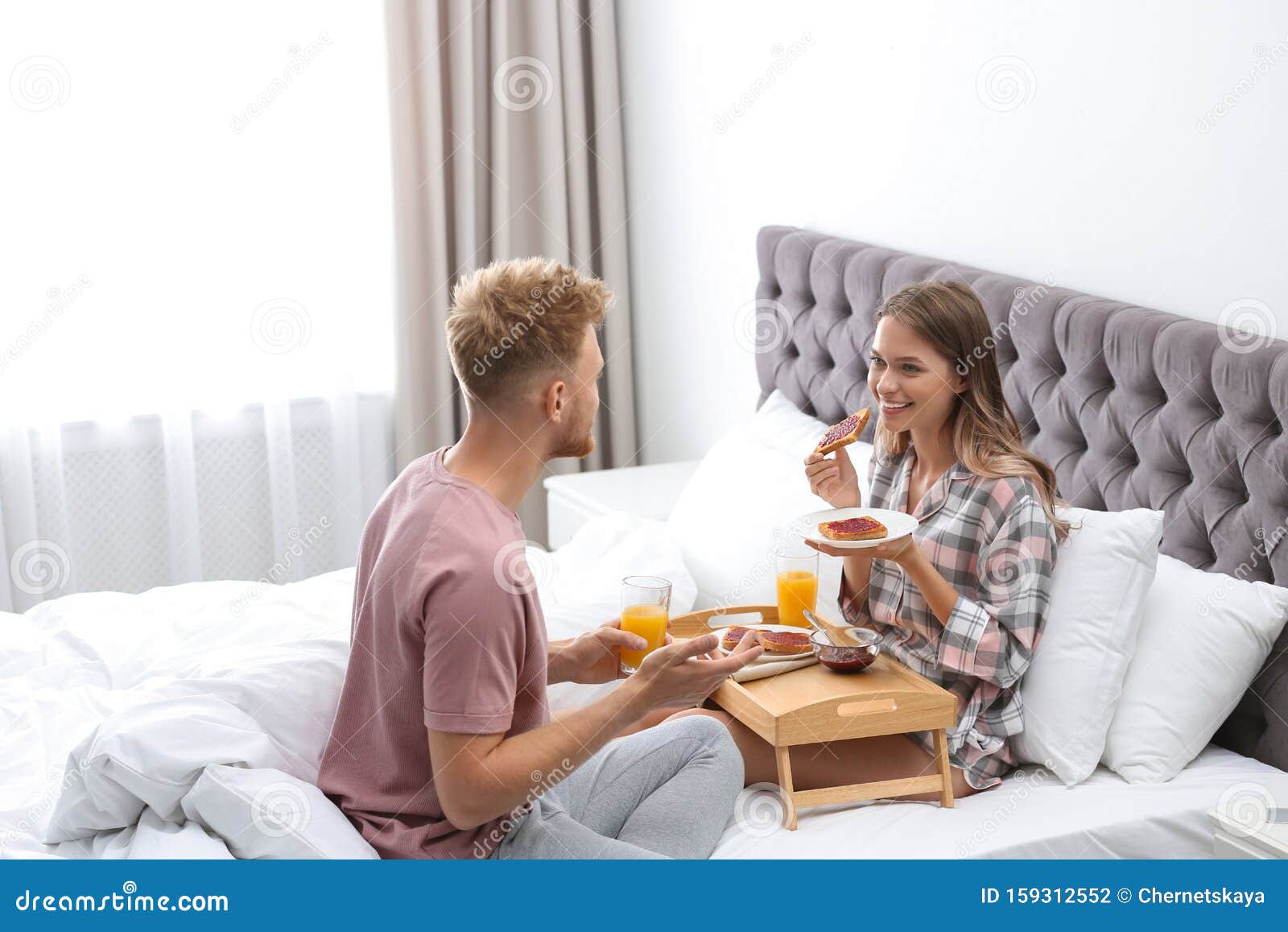 Happy Young Couple Having Romantic Breakfast on Bed Stock Photo Image