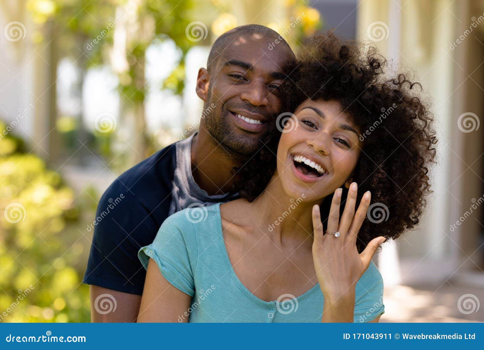 happy young couple with woman showing her wedding ring