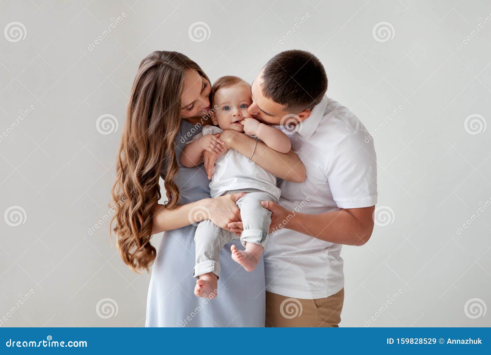 Happy Young Family. Beautiful Mother and Father Kissing Their Baby ...