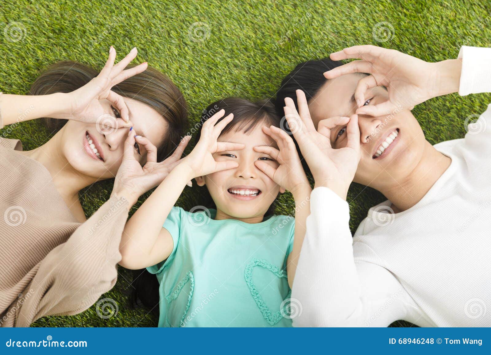 happy young family lying on the grass