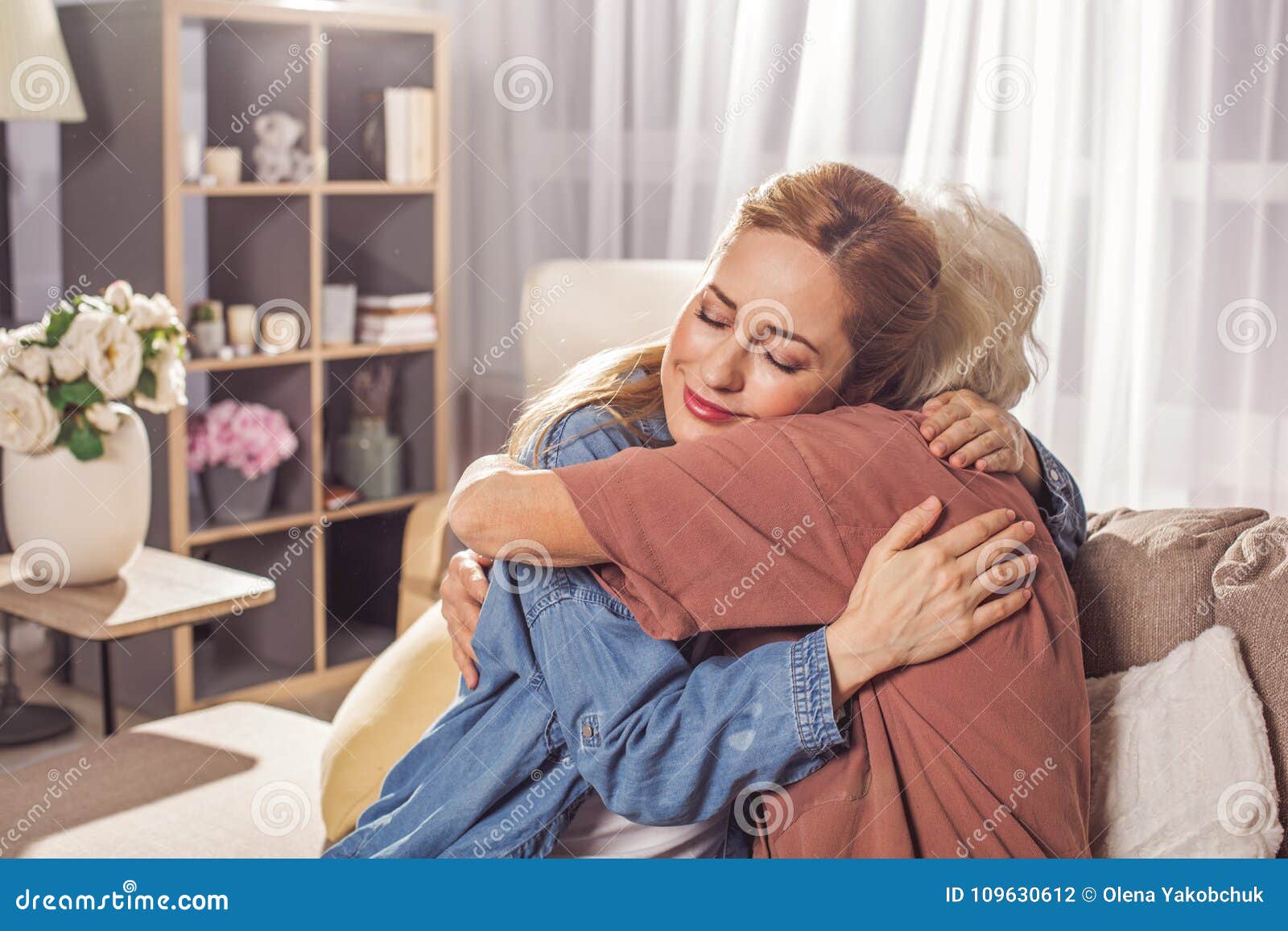 glad girl hugging granny in room