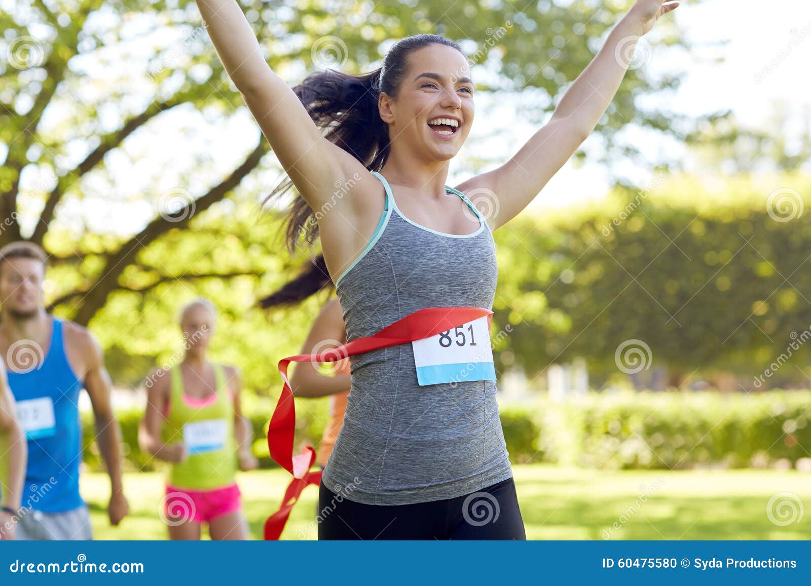 happy young female runner winning on race finish