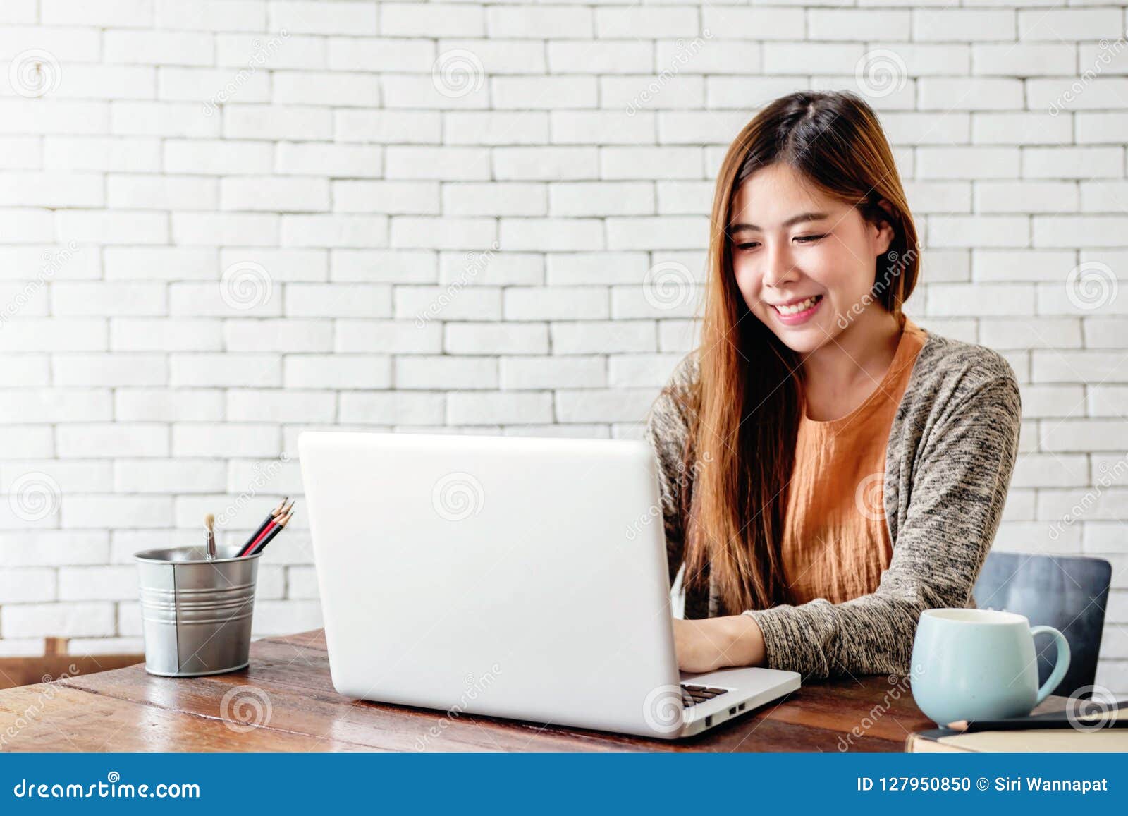 happy young freelancer woman working on computer laptop in cozy