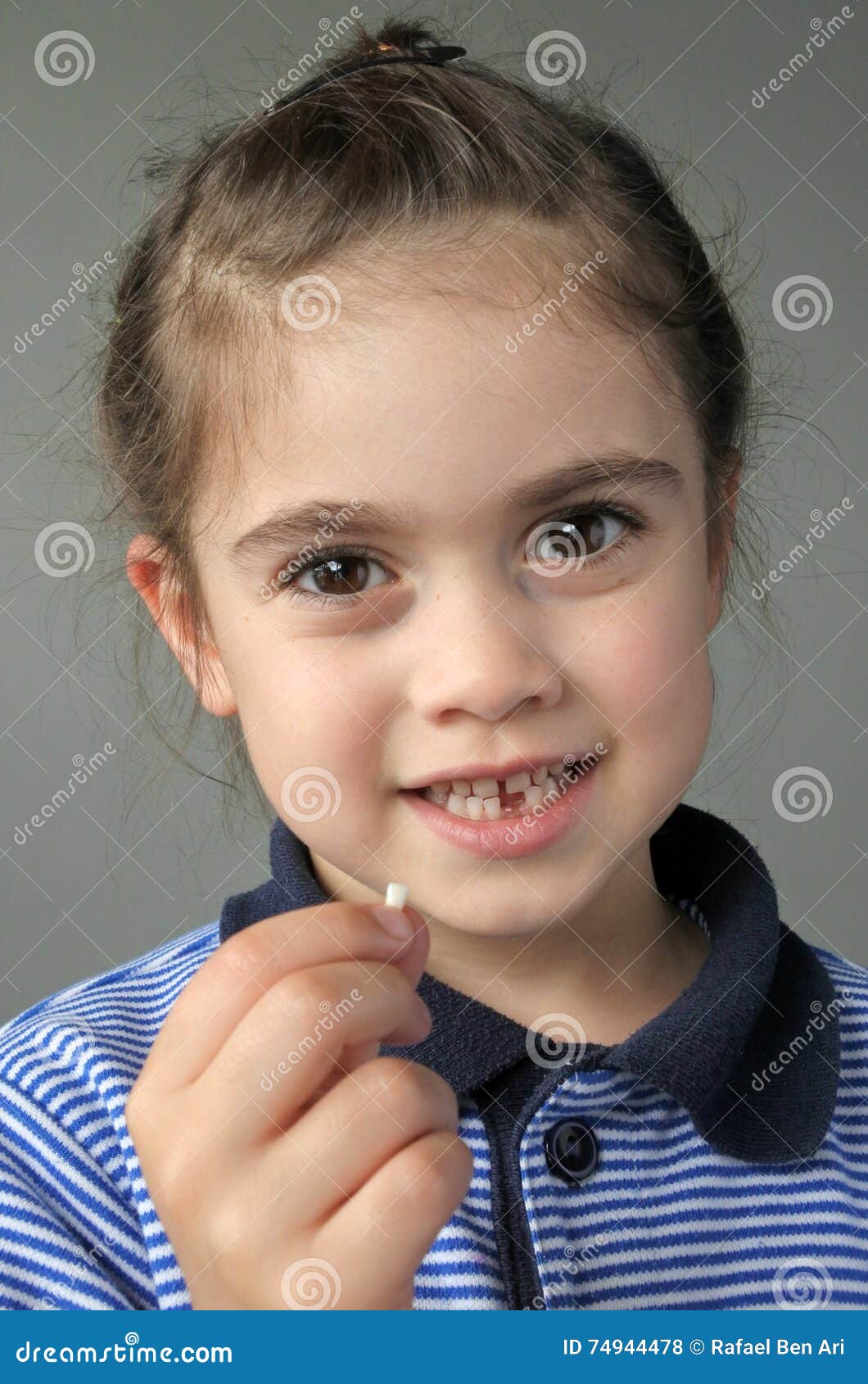 Happy Young Girl Holds Her First Falling Milk Teeth Stock Photo - Image