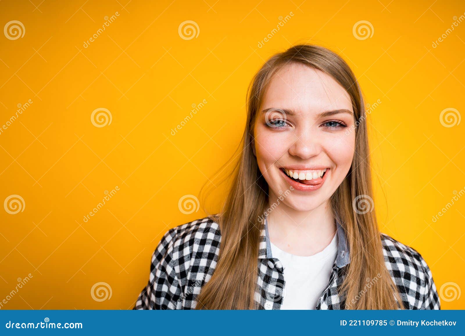 happy young girl in shirt smiling and laughing showing white teeth and standing on yellow background