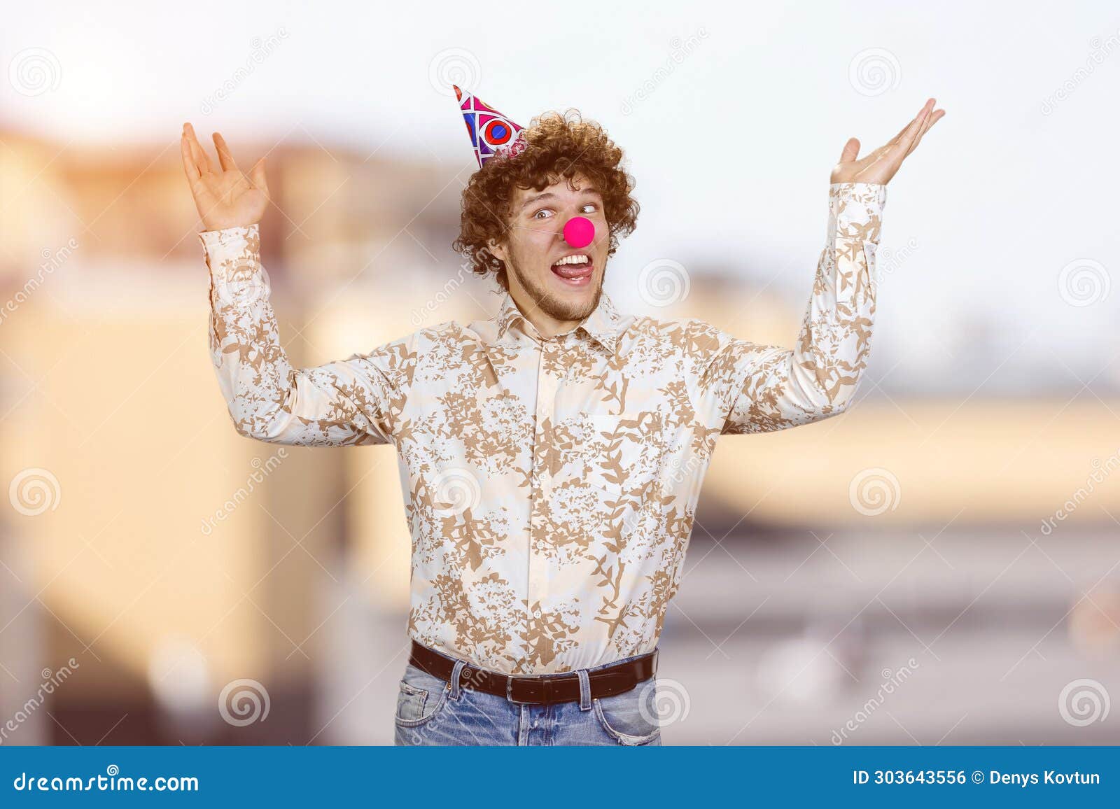 happy young guy with clown nose fooling around making funny faces.