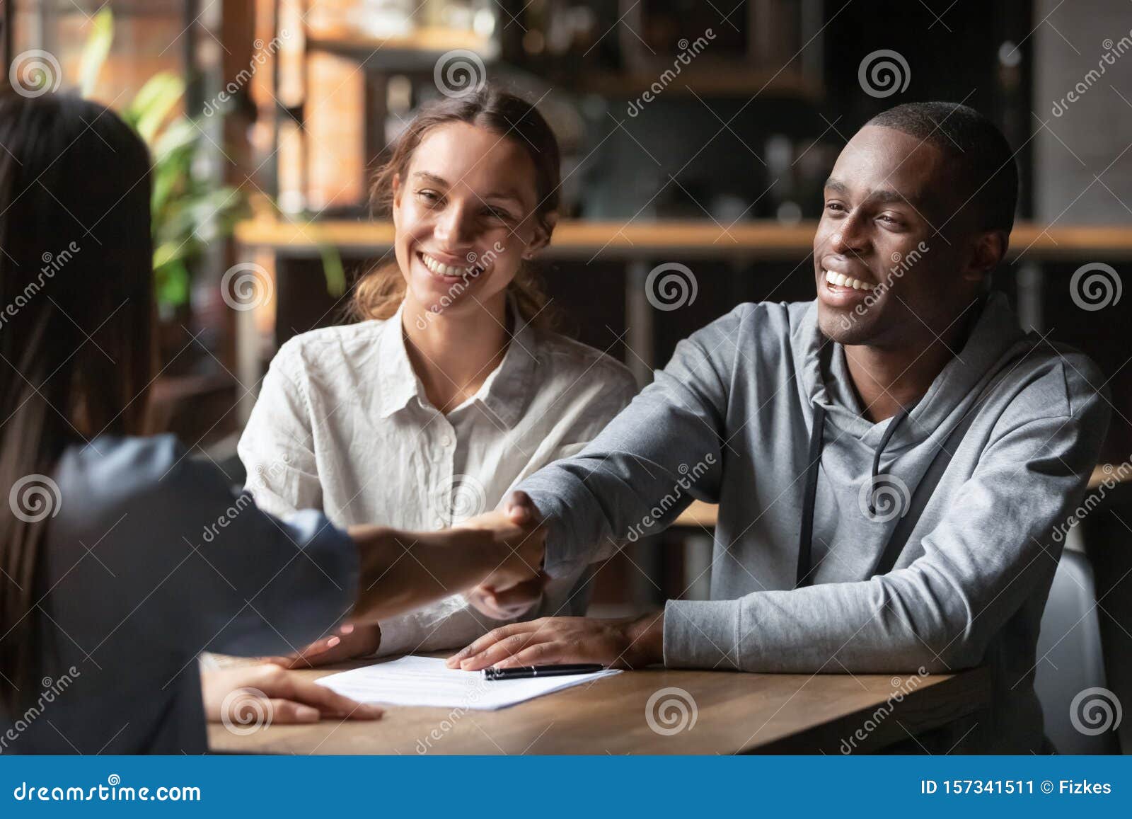 happy interracial couple handshake bank manager take mortgage loan