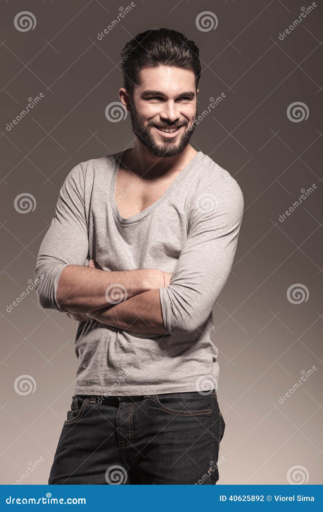 Happy Young Man with Beard Standing with Hands Crossed Stock Photo ...