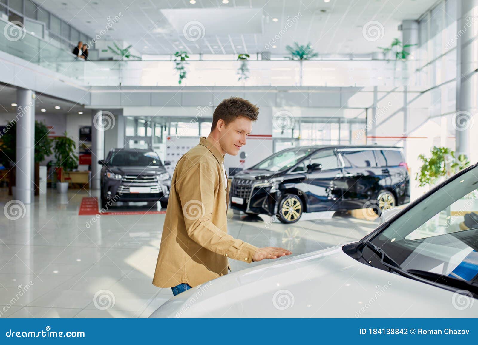 happy young man checking all s and looking at ideality of car