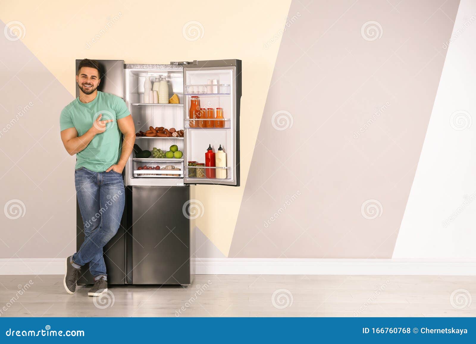 Happy Young Man Near Open Refrigerator Indoors Stock Photo Image
