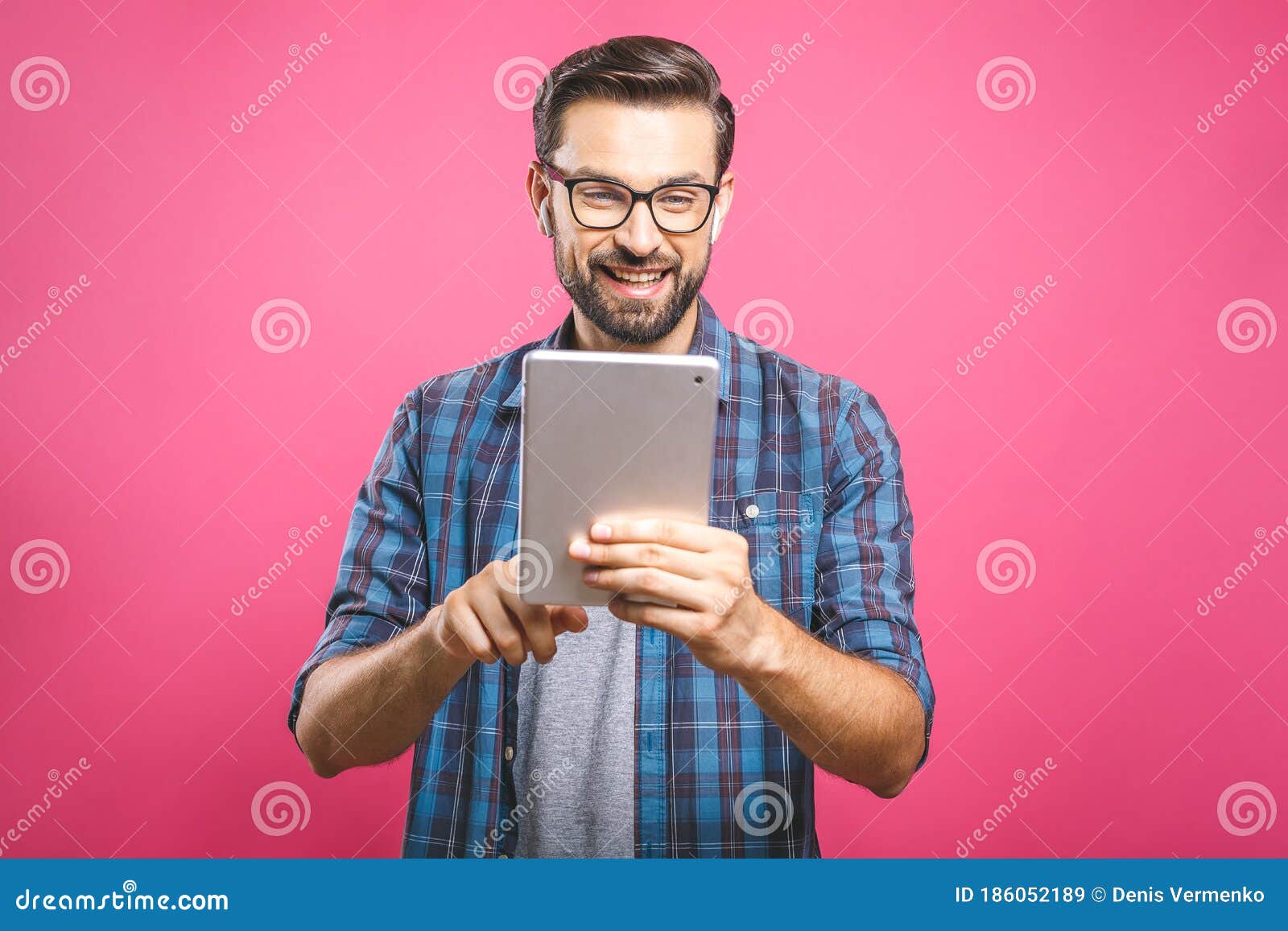 Happy Young Man in Plaid Shirt Standing and Using Tablet Over Pink ...