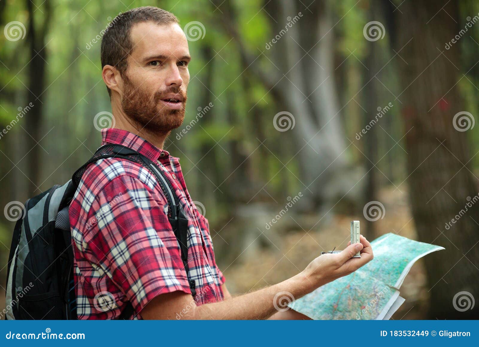 Young Man Hiking through Forest and Looking at the Map Stock Image ...