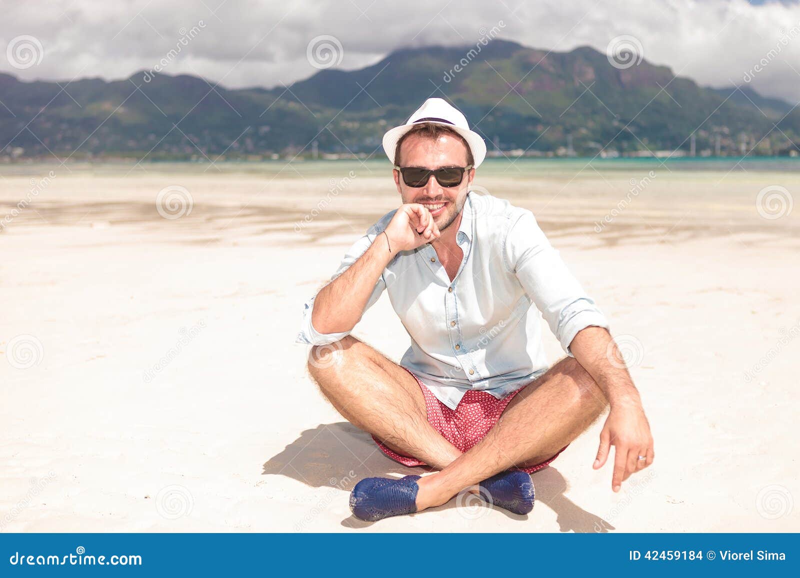 Happy Young Man Thinking while Sitting on Beach Stock Photo - Image of ...