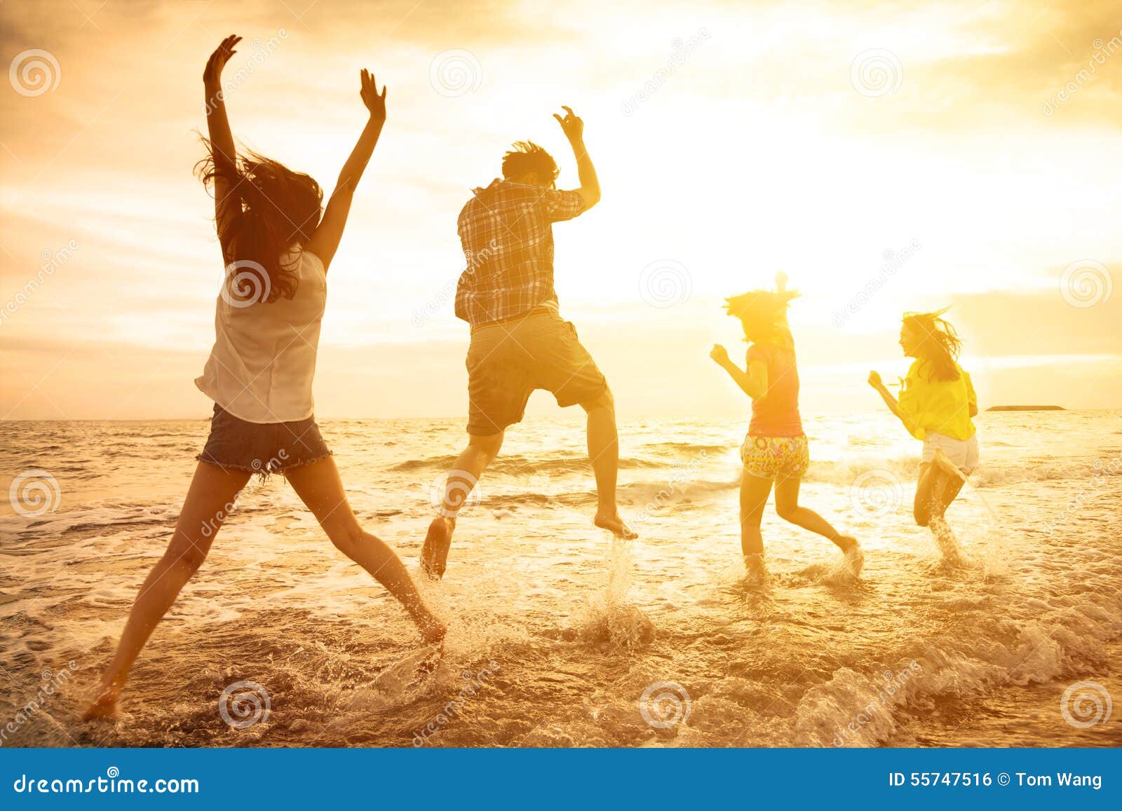 happy young people dancing on the beach