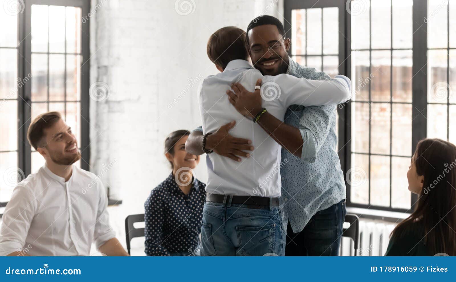 happy young people hug engaged in group motivation training