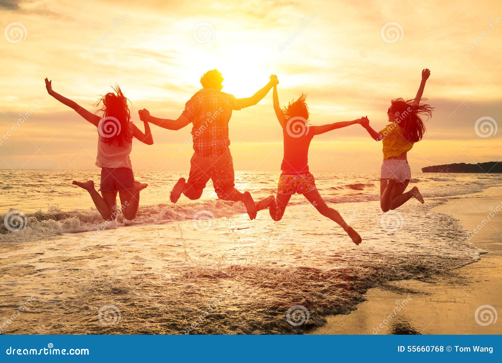 happy young people jumping on the beach