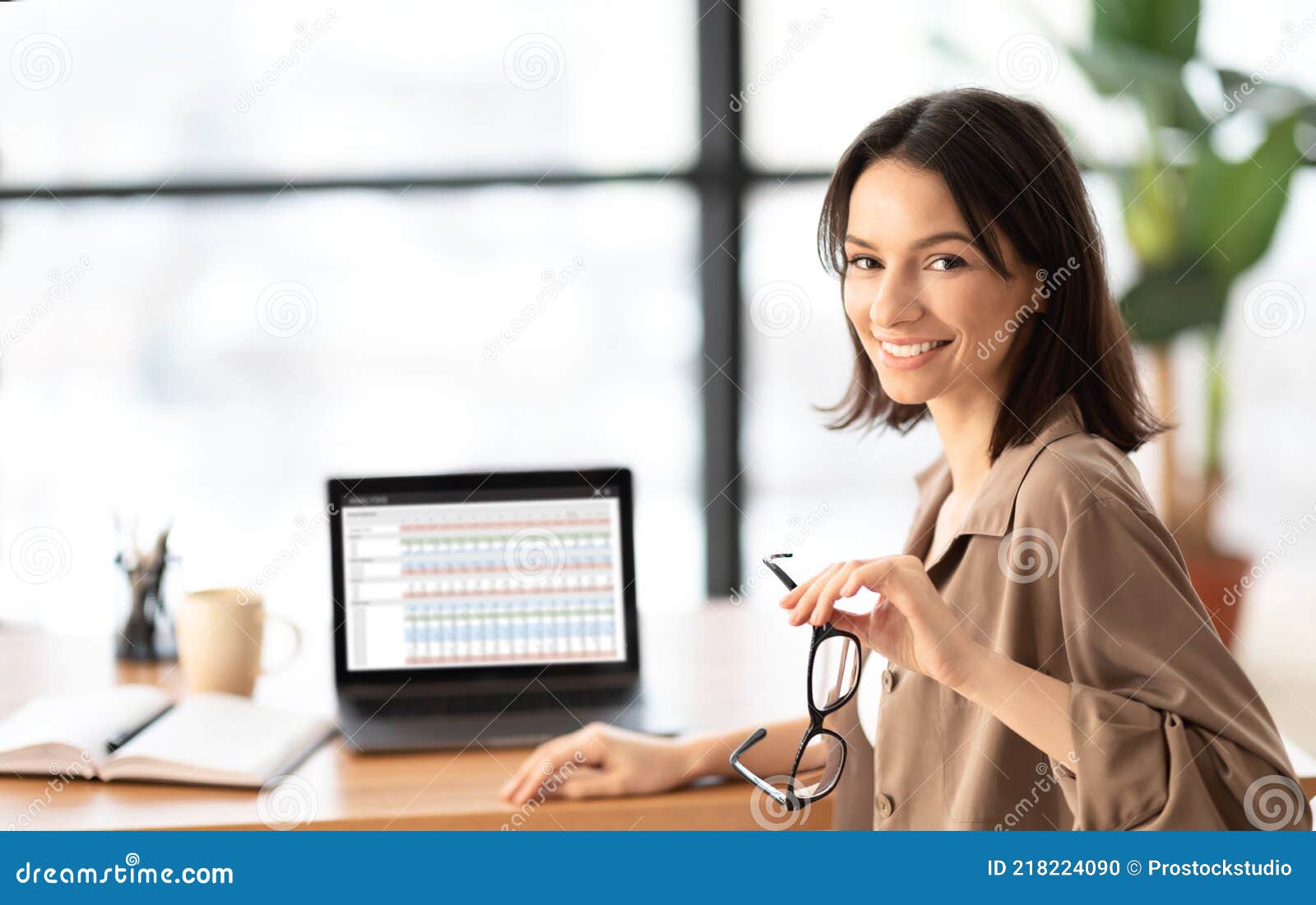 happy young woman business analyst using laptop