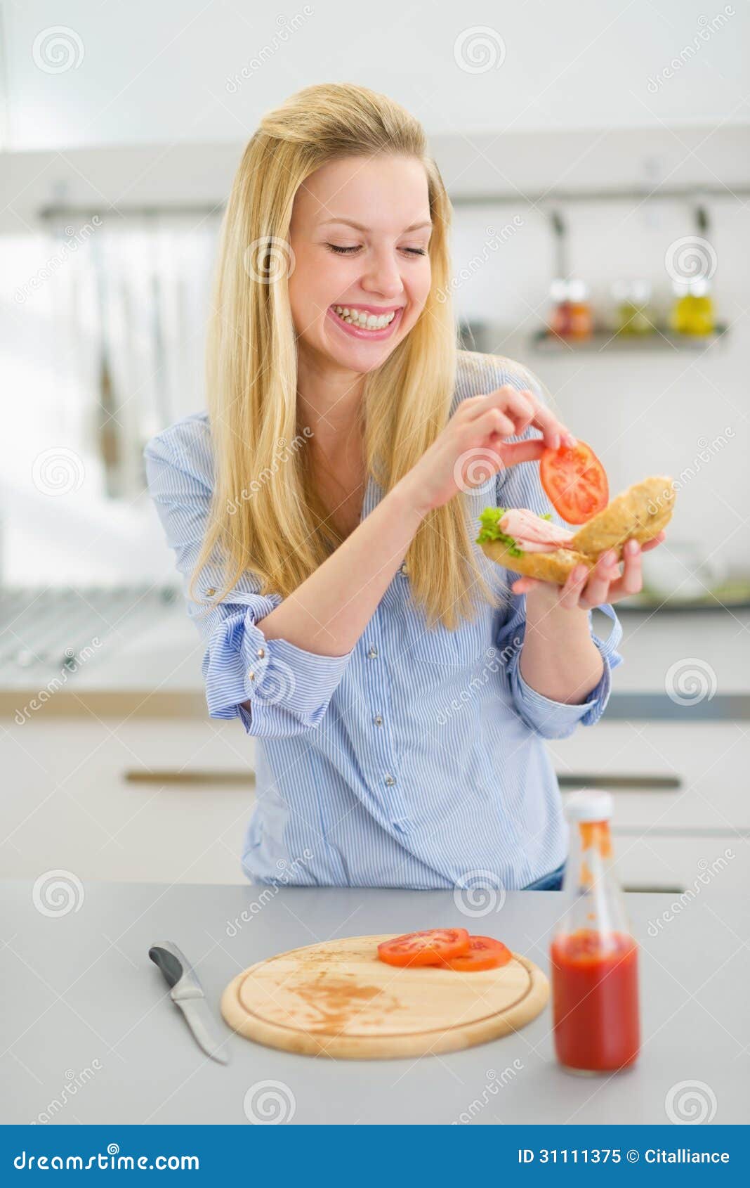 Happy Young Woman Making Sandwich In Kitchen Royalty Free 