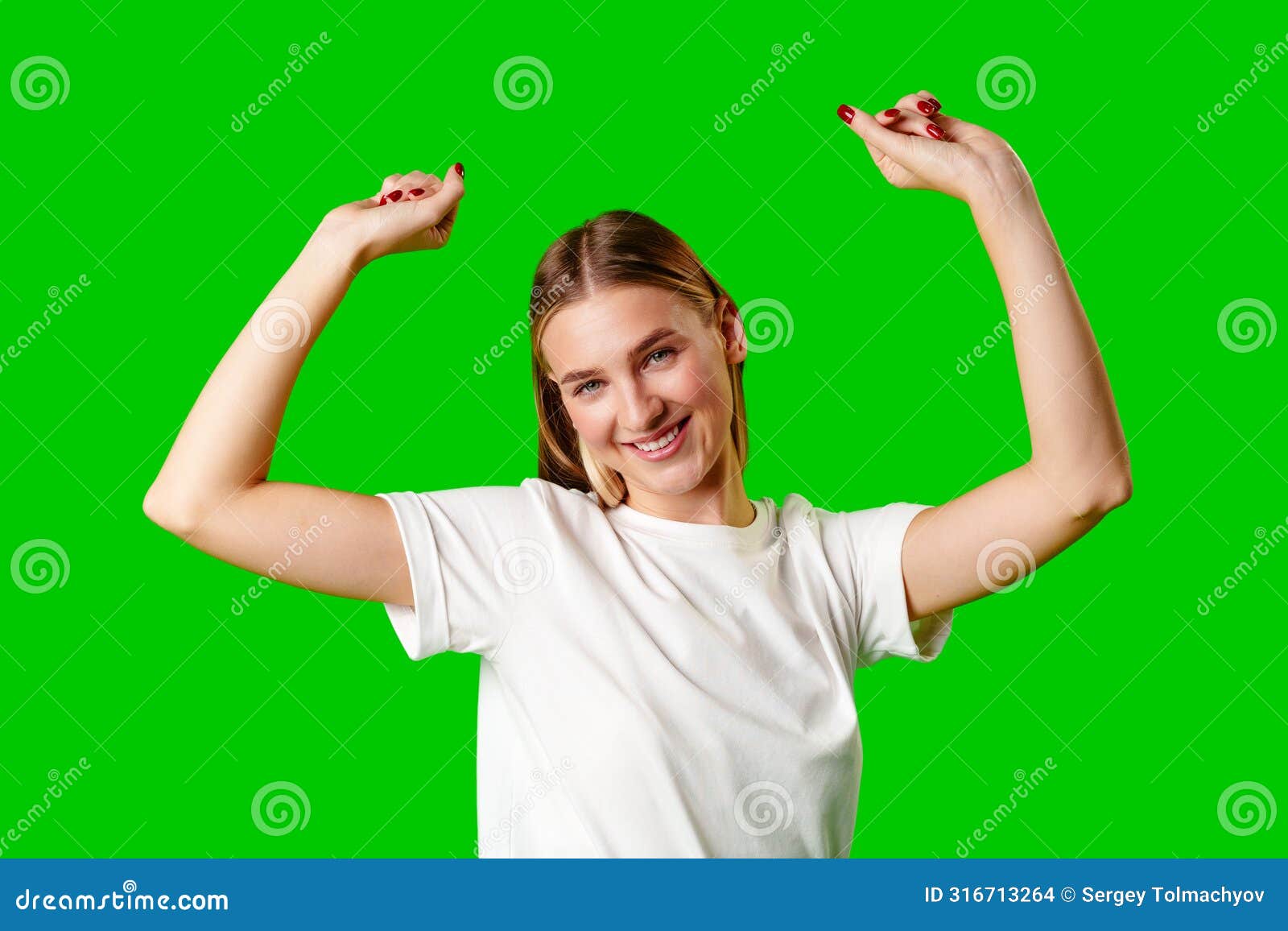 happy young woman raising fists against green background