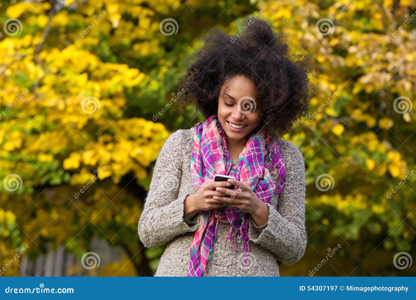 happy young woman reading text message on mobile phone