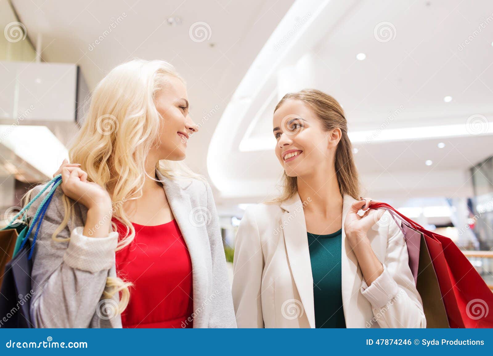 Happy Young Women with Shopping Bags in Mall Stock Photo - Image of ...