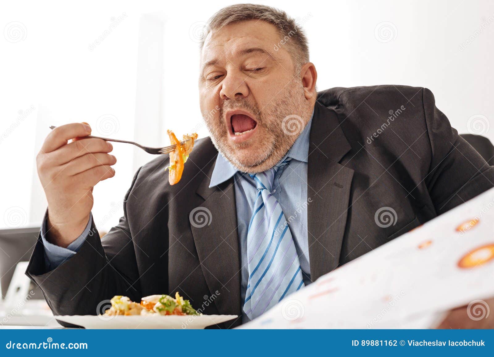 hardworking tireless employee working a eating at the same time hard working employee