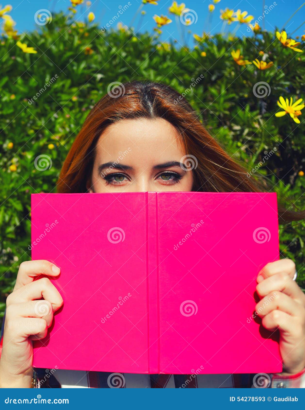 Сharming young woman with <b>pink book</b> held up close to her face - harming-young-woman-pink-book-held-up-close-to-her-face-portrait-charming-cute-female-covering-half-54278593