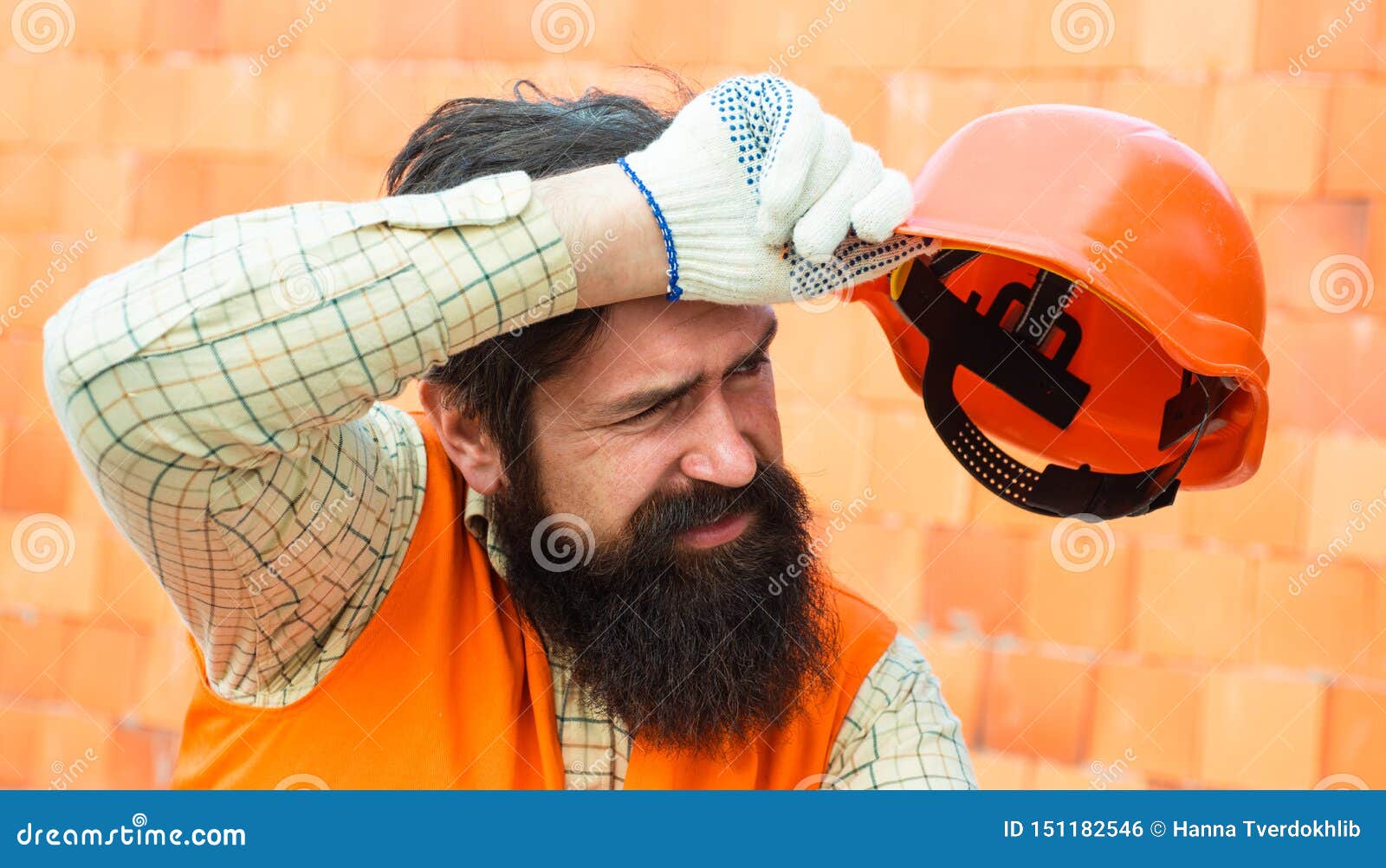 Harte Arbeit an einer Baustelle Schwerer Beruf Männlicher Erbauer wischt Schweiß von der Braue ab M?der Erbauer Körperliche Arbeit bei heißem Wetter Hitze und Sicherheit am Arbeitsplatz