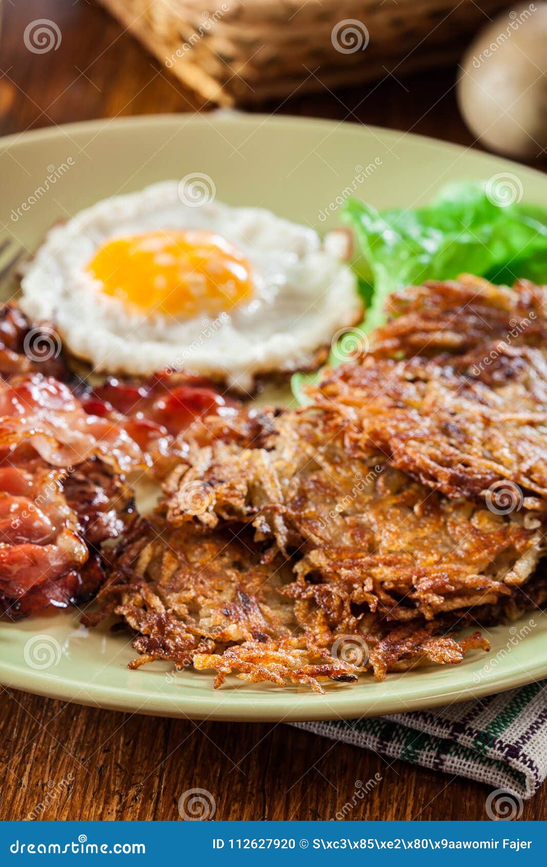 Hash Browns. Potato Pancakes with Crispy Fried Bacon and Fried Egg