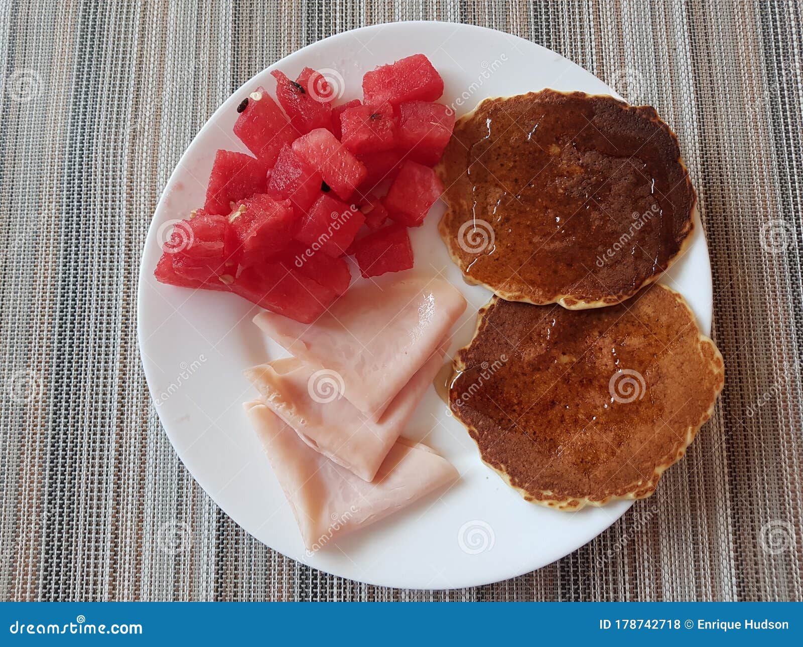Having Watermelon, Ham and Hotcakes with Honey for Breakfast Stock