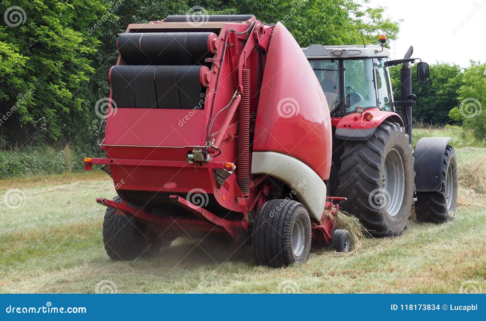 Hay Baler Machine Pulled By A Red Tractor On A Freshly Cut Field Stock Photo Image Of Hayfield Industry