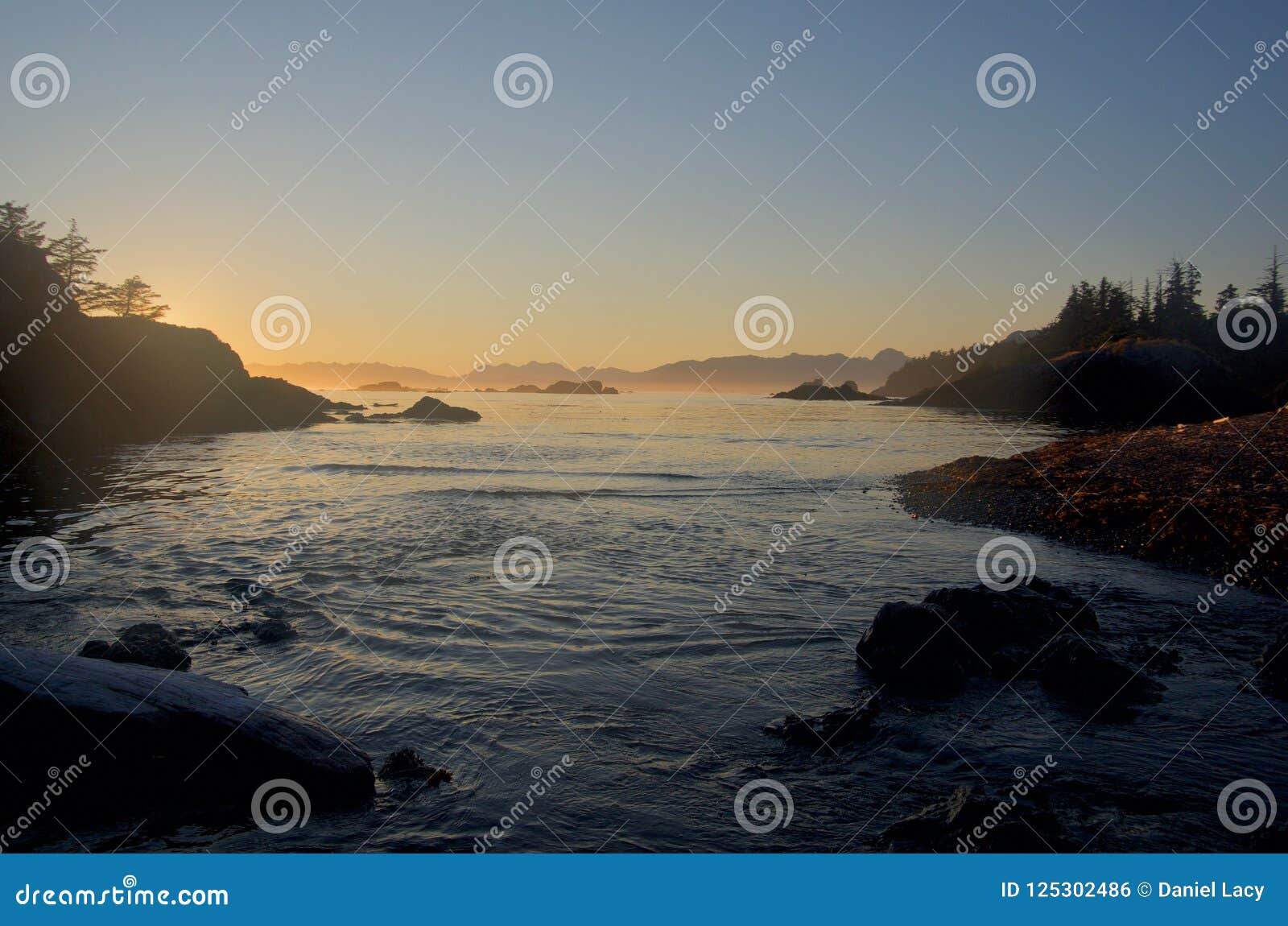 hazy sunset viewed from beach on spring island on calm summer evening