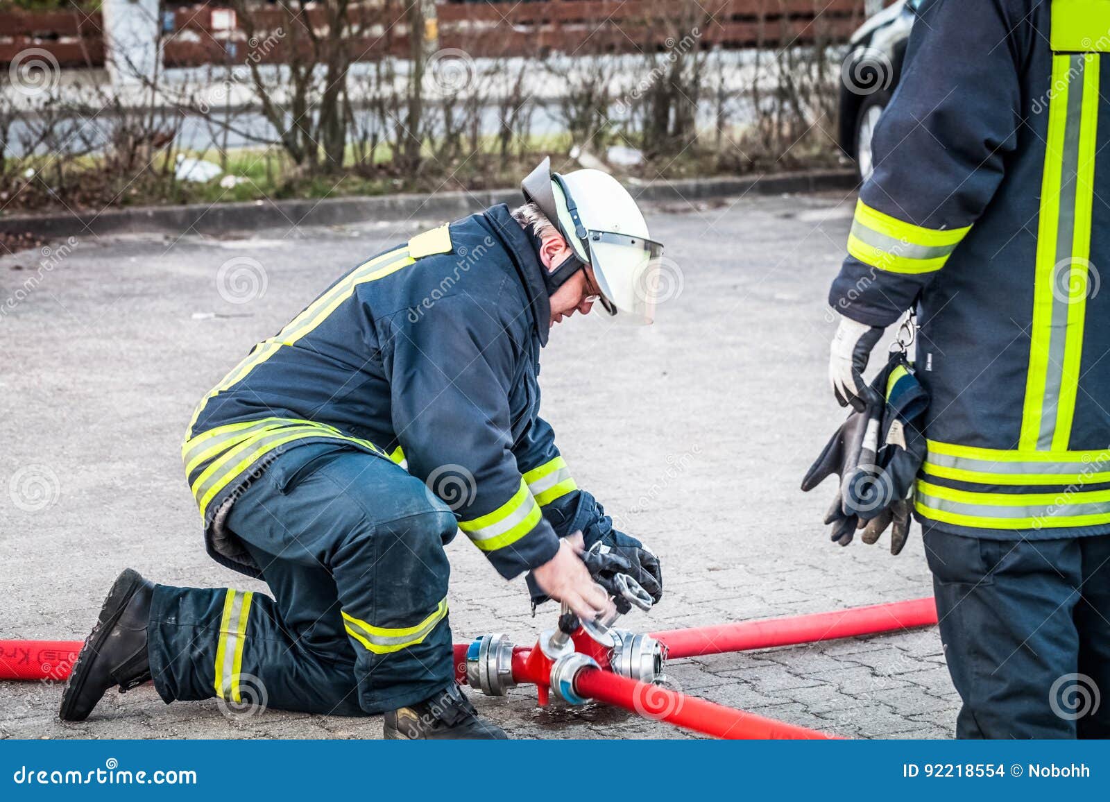 HDR Firefighter in Action and Connects Two Fire Hoses Editorial Stock