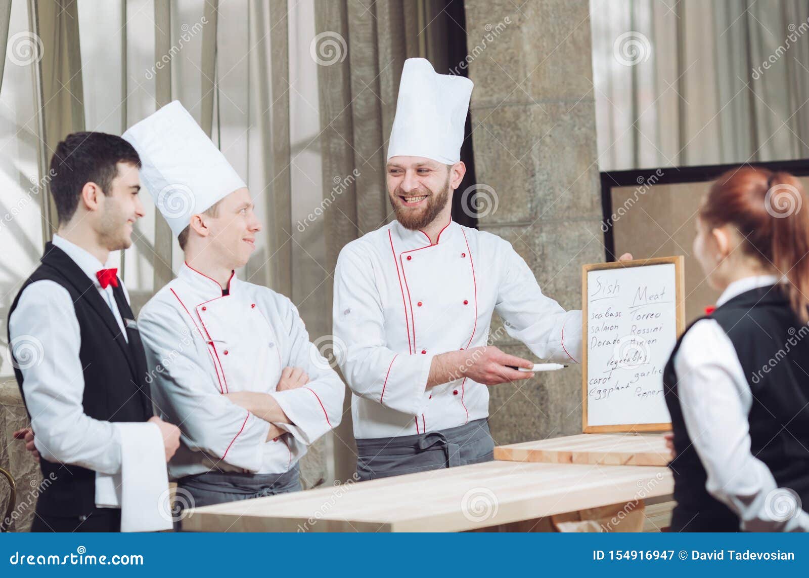 Head Chef and His Staff in Kitchen. Interacting To in Commercial Kitchen. Stock Image Image of