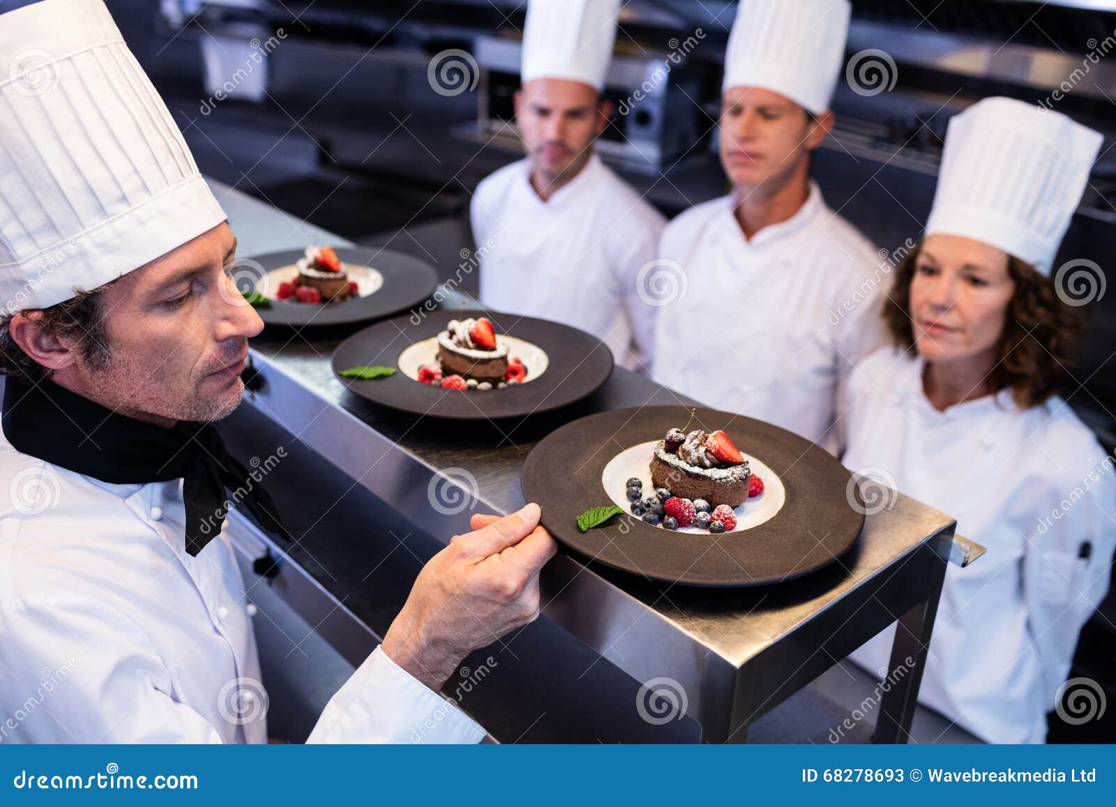 Head Chef Inspecting Dessert Plates on at Order Station Stock Image