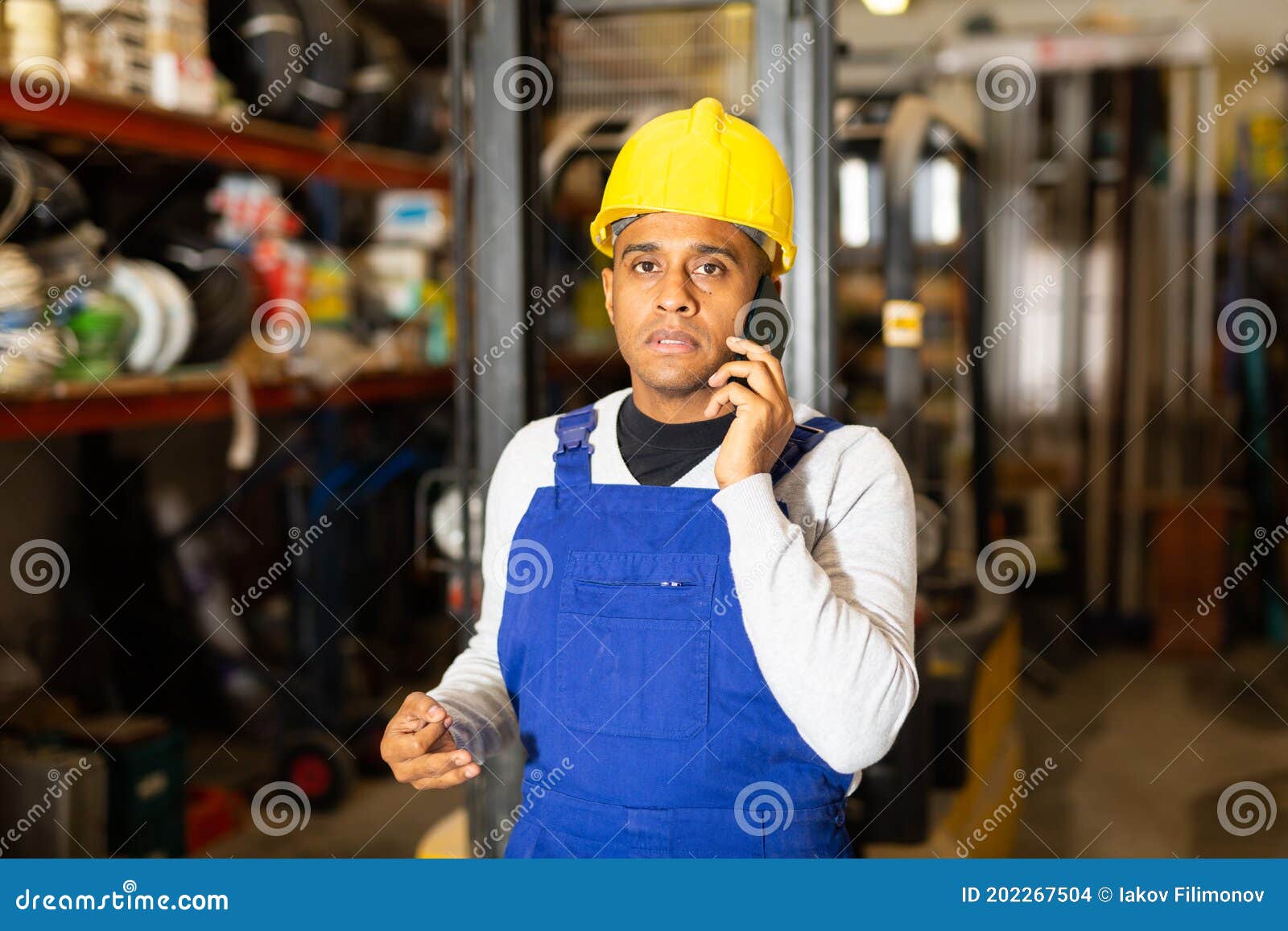 Head of Construction Store Talking on Mobile Phone in Warehouse Stock