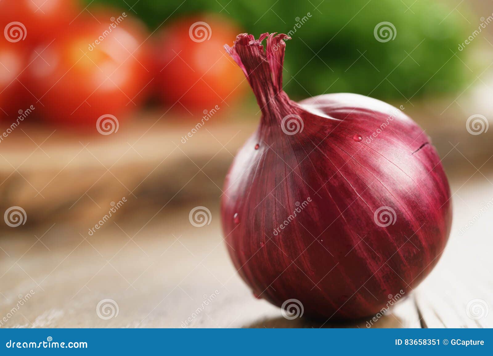 Head of Red Onion on Wooden Kitchen Table with Copy Space Stock Image