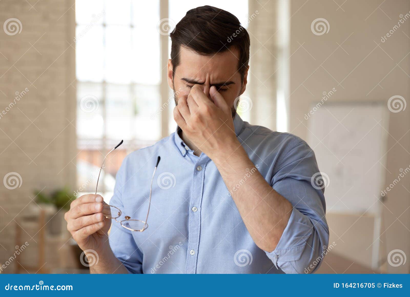employee suffering from dry eyes syndrome or eyestrain.