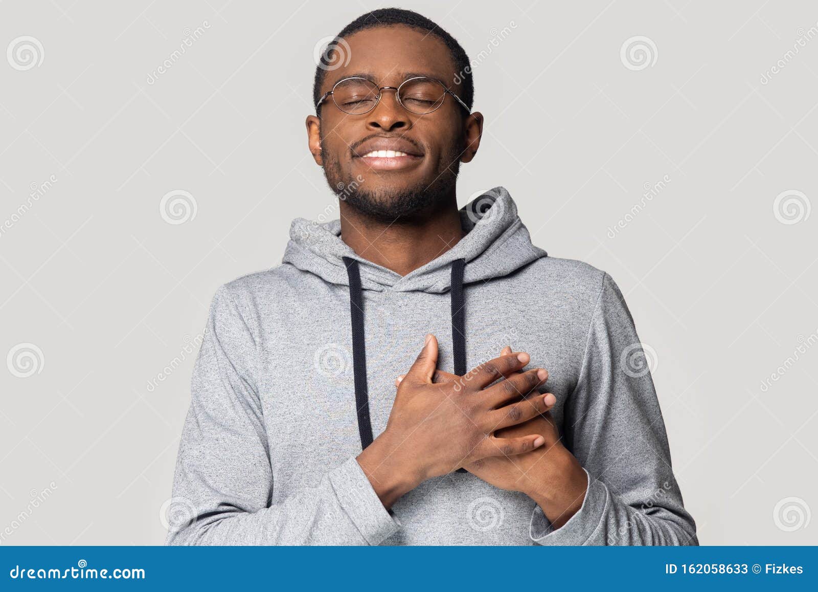 head shot grateful african american man holding hands on chest