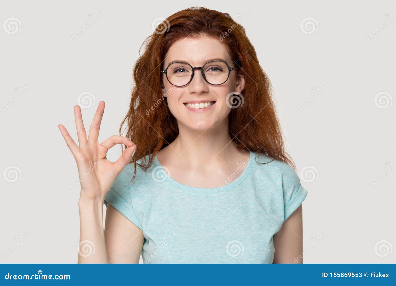 head shot portrait young smiling woman showing okey gesture.